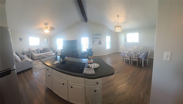 4222 Mason Dr, Galveston, TX 77554 - kitchen with freestanding refrigerator, open floor plan, dark wood-style floors, white cabinets, and vaulted ceiling with beams