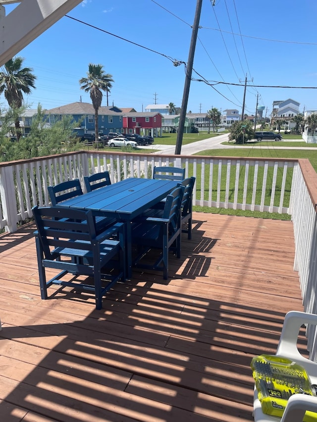 4222 Mason Dr, Galveston, TX 77554 - wooden terrace featuring a lawn, outdoor dining area, and a residential view