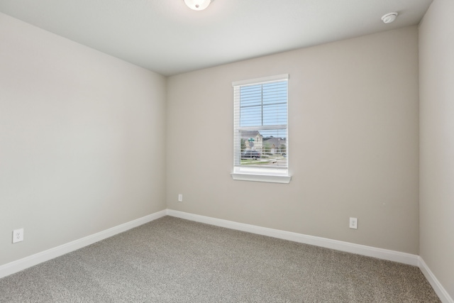unfurnished room with baseboards and carpet
