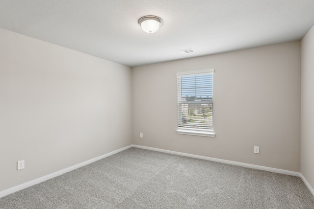 carpeted empty room with visible vents and baseboards