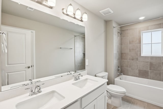 bathroom with visible vents, a sink, shower / bath combination, and toilet