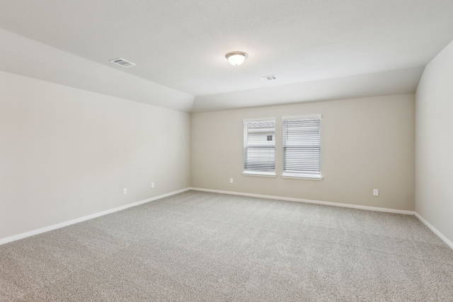 carpeted empty room featuring baseboards and visible vents