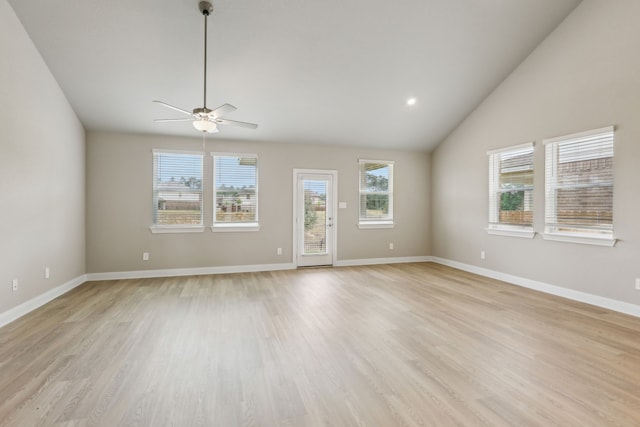 unfurnished living room featuring plenty of natural light, light wood-style flooring, ceiling fan, and lofted ceiling