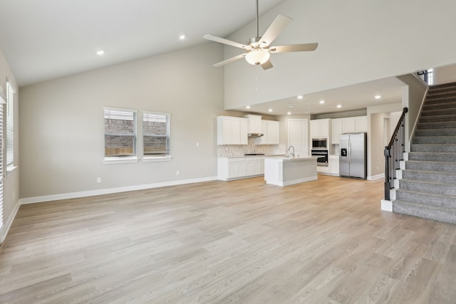 unfurnished living room with baseboards, a ceiling fan, recessed lighting, and stairway
