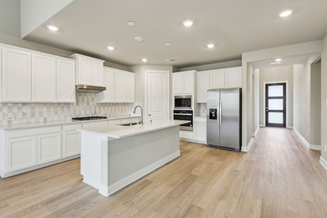 kitchen with a sink, tasteful backsplash, stainless steel appliances, and white cabinets