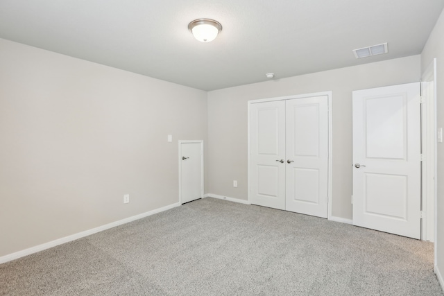 unfurnished bedroom with visible vents, carpet, baseboards, and a closet