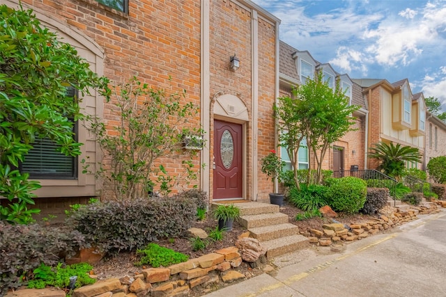 property entrance featuring brick siding
