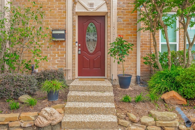 view of exterior entry featuring brick siding