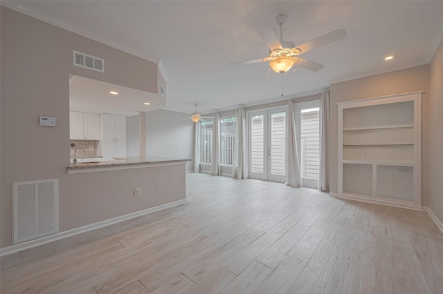 unfurnished living room featuring ceiling fan, visible vents, baseboards, and light wood-type flooring