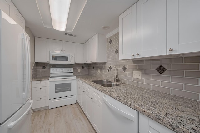 kitchen featuring a sink, decorative backsplash, white appliances, and white cabinetry