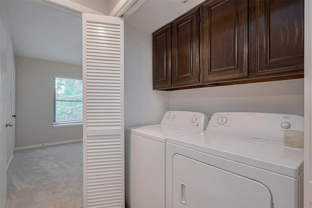 clothes washing area with light colored carpet, cabinet space, independent washer and dryer, and baseboards