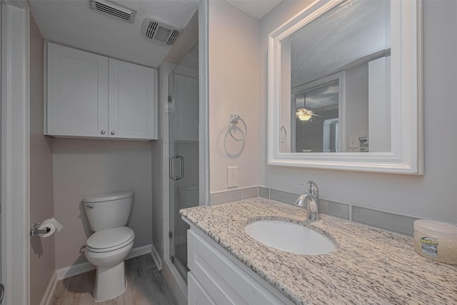 bathroom with visible vents, a stall shower, wood finished floors, vanity, and toilet