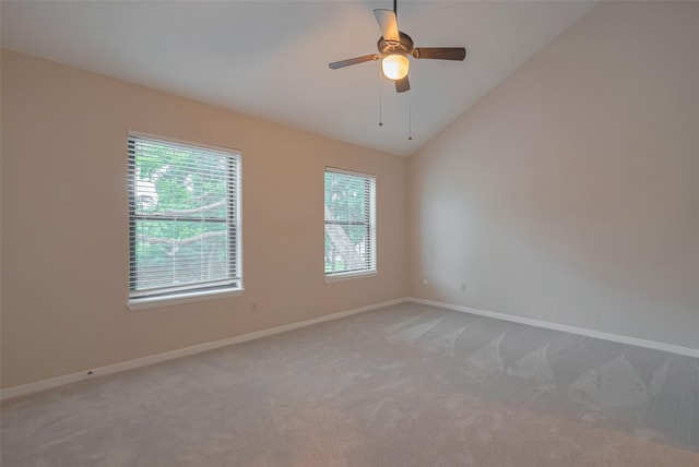 carpeted empty room featuring baseboards, a wealth of natural light, and vaulted ceiling