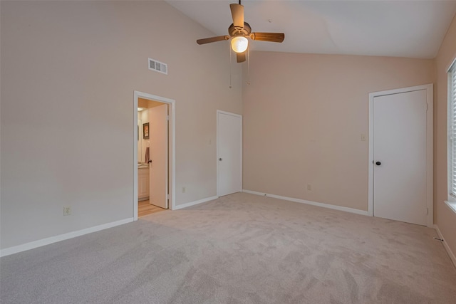 unfurnished bedroom with visible vents, baseboards, high vaulted ceiling, and light colored carpet