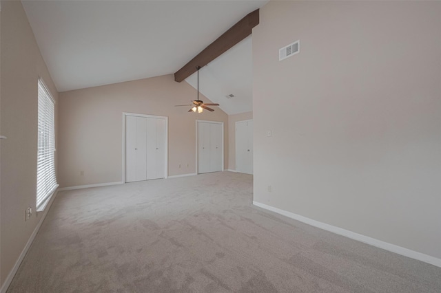empty room with visible vents, carpet flooring, baseboards, and beam ceiling
