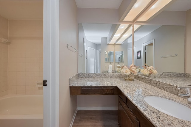 bathroom with vanity, baseboards, shower / bathtub combination, and wood finished floors