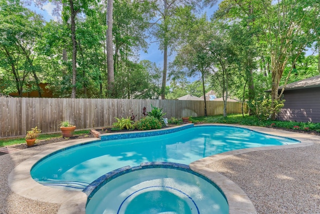 view of swimming pool with a fenced backyard and a pool with connected hot tub