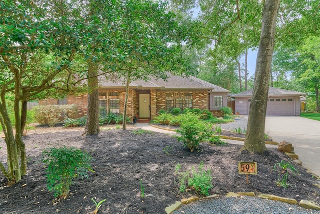 view of front facade with brick siding, driveway, a shingled roof, and a garage