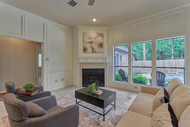 living area with visible vents, plenty of natural light, light tile patterned floors, and a decorative wall