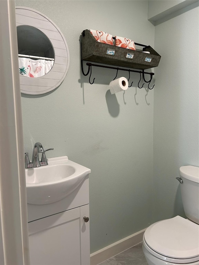 full bath with vanity, baseboards, and toilet