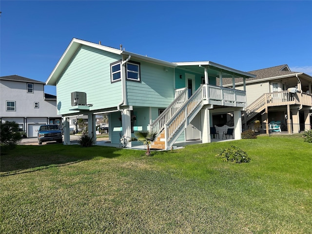 back of property with central air condition unit, a yard, and stairway