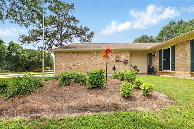 exterior space with brick siding and a front lawn
