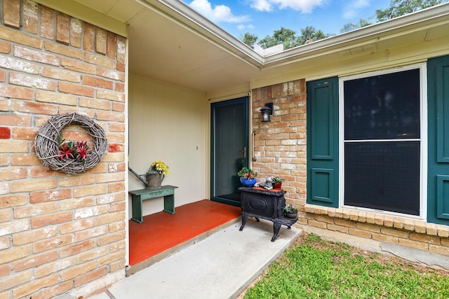 doorway to property featuring brick siding