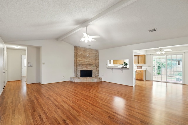 unfurnished living room featuring visible vents, a ceiling fan, light wood-style flooring, and vaulted ceiling with beams