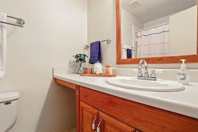 full bathroom featuring vanity, toilet, and visible vents