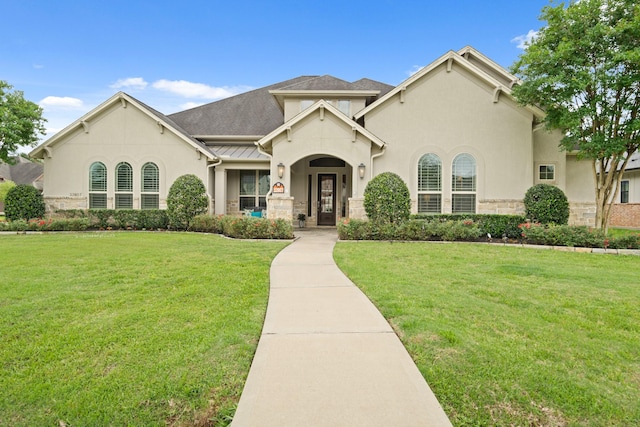 view of front of property with stucco siding, stone siding, and a front yard