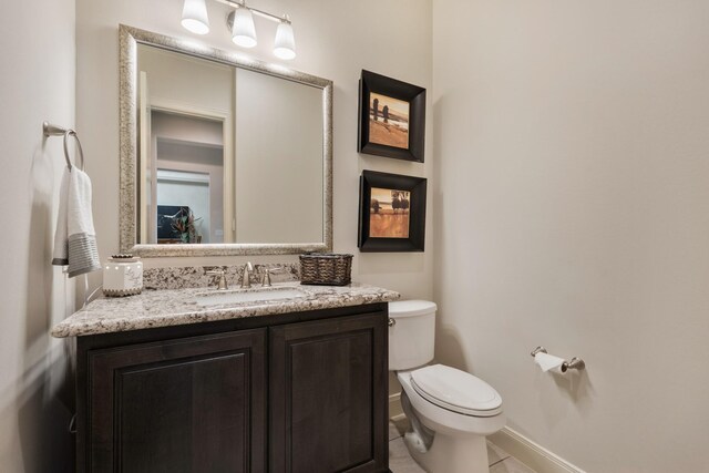 half bath featuring toilet, baseboards, tile patterned flooring, and vanity