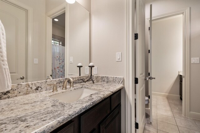bathroom with tile patterned flooring, vanity, toilet, recessed lighting, and baseboards