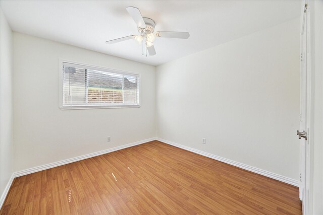 unfurnished room with baseboards, a ceiling fan, and light wood-style flooring