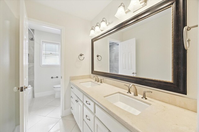 bathroom featuring double vanity, toilet, a sink, and tile patterned flooring