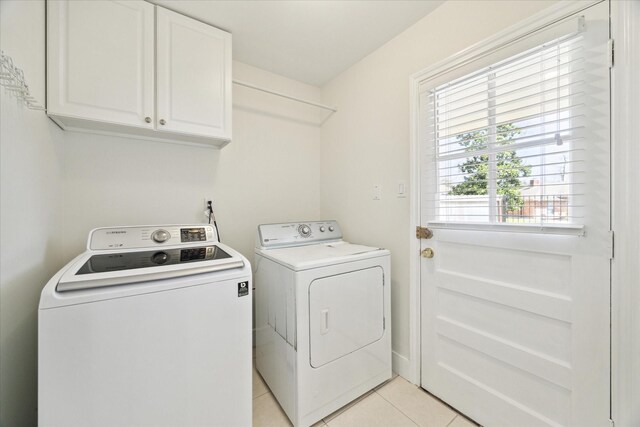 washroom with washer and clothes dryer, cabinet space, and light tile patterned floors