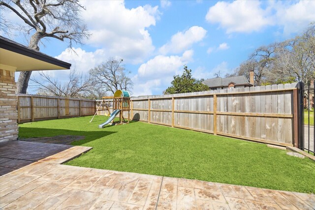 view of yard with a patio, a fenced backyard, and a playground