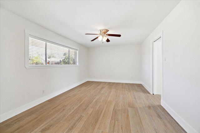 spare room with baseboards, ceiling fan, and light wood-style flooring
