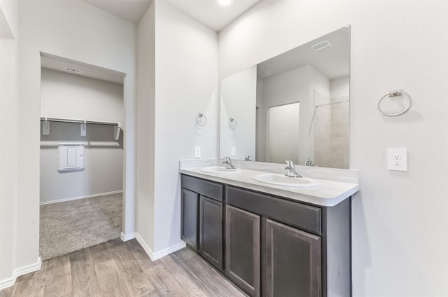 16524 Cascading Pines Ct, Conroe, TX 77302 - bathroom featuring a sink, baseboards, double vanity, and wood finished floors