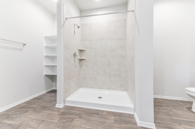 16524 Cascading Pines Ct, Conroe, TX 77302 - full bathroom featuring baseboards, wood finished floors, toilet, and a shower stall