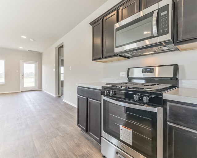 16524 Cascading Pines Ct, Conroe, TX 77302 - kitchen featuring light countertops, baseboards, appliances with stainless steel finishes, and light wood finished floors