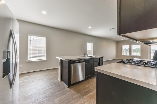 16524 Cascading Pines Ct, Conroe, TX 77302 - kitchen featuring baseboards, stainless steel appliances, light wood-type flooring, and a wealth of natural light