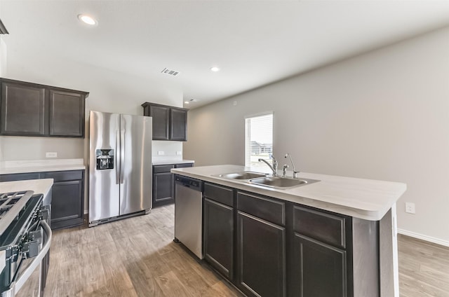 16524 Cascading Pines Ct, Conroe, TX 77302 - kitchen featuring visible vents, light countertops, a sink, light wood finished floors, and appliances with stainless steel finishes