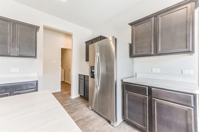 16524 Cascading Pines Ct, Conroe, TX 77302 - kitchen featuring washing machine and clothes dryer, dark brown cabinetry, stainless steel fridge with ice dispenser, and light countertops