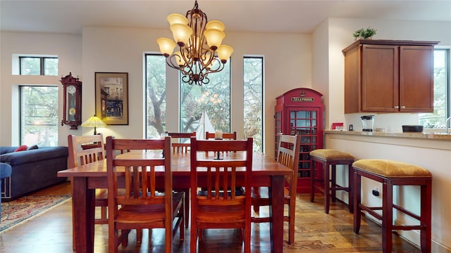 dining space featuring an inviting chandelier, wood finished floors, and a healthy amount of sunlight
