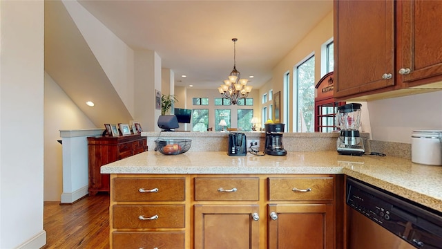 kitchen with stainless steel dishwasher, a peninsula, a notable chandelier, and light countertops