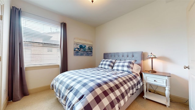 bedroom with baseboards and light carpet