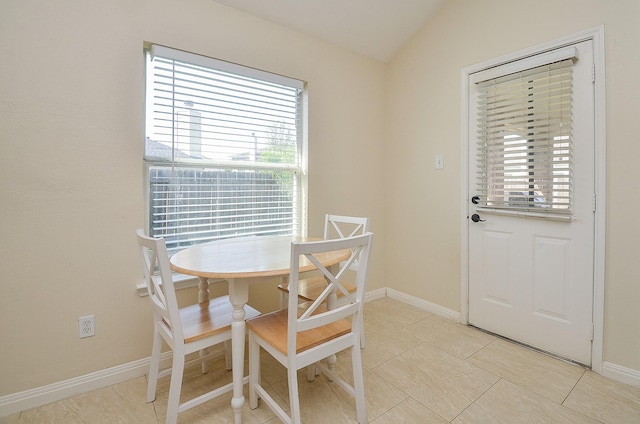18235 Bonham Oaks Ct, Richmond, TX 77407 - dining space featuring baseboards, light tile patterned floors, lofted ceiling, and a wealth of natural light