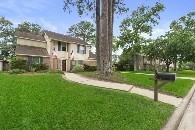 view of front of property featuring brick siding and a front lawn