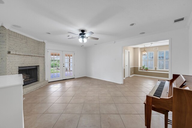 unfurnished living room with light tile patterned floors, a healthy amount of sunlight, ornamental molding, and visible vents