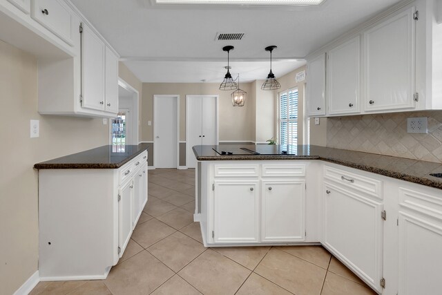 kitchen featuring white cabinets, a peninsula, visible vents, and light tile patterned flooring